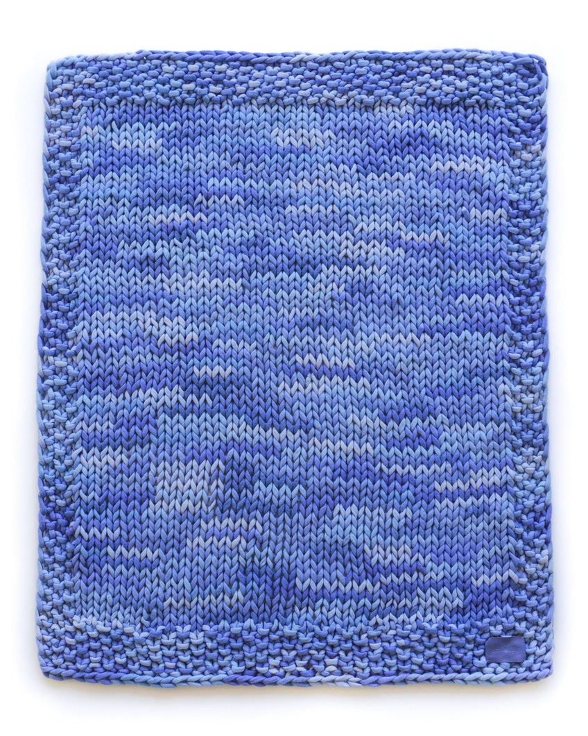 Pure cashmere chunky knit throw blanket in marled sky blue. Flat knit with textured border.